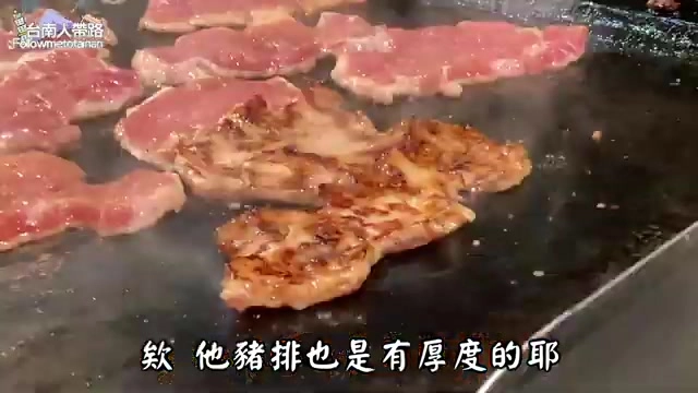 鐵板上正在煎烤的多片肉排,色澤金黃焦香