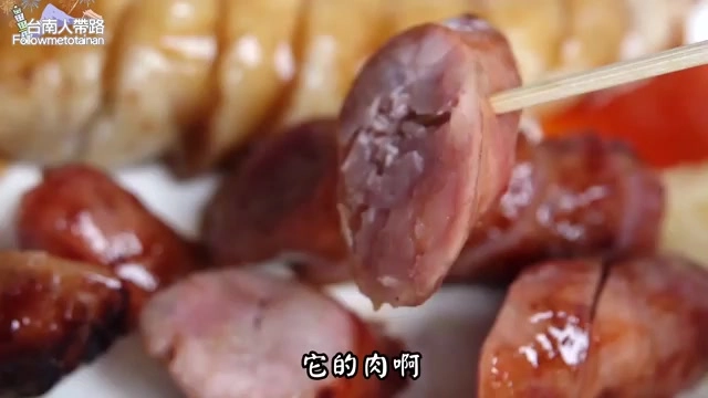 筷子夾起一片香腸切面,肉質呈現粉紅色澤,紋理清晰可見