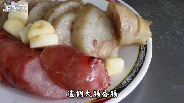大腸香腸拼盤配上生蒜片，紅腸與糯米大腸切片色澤誘人