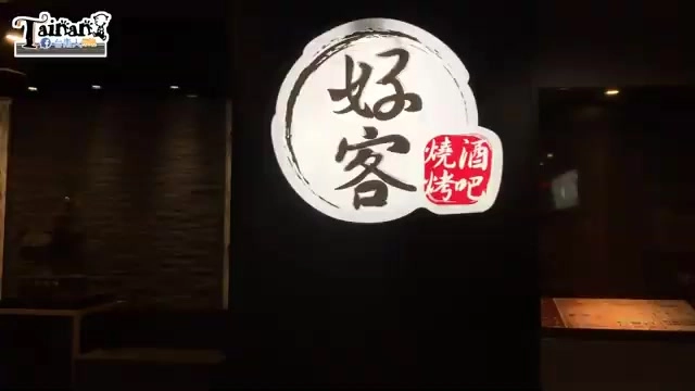 黑底招牌上以毛筆字寫著「好客」，旁邊紅色印章式標誌寫著「燒烤酒吧」