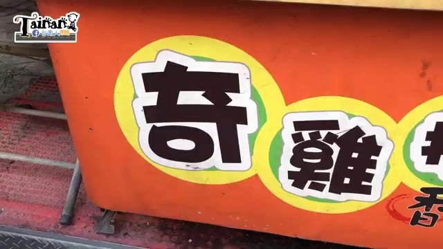 店家招牌特寫，橘底黃圈上寫著「奇雞排」字樣，色彩鮮明醒目