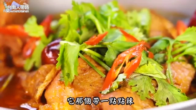 鍋中盛著醬色濃郁的乾鍋雞塊，鋪滿新鮮香菜與辣椒點綴