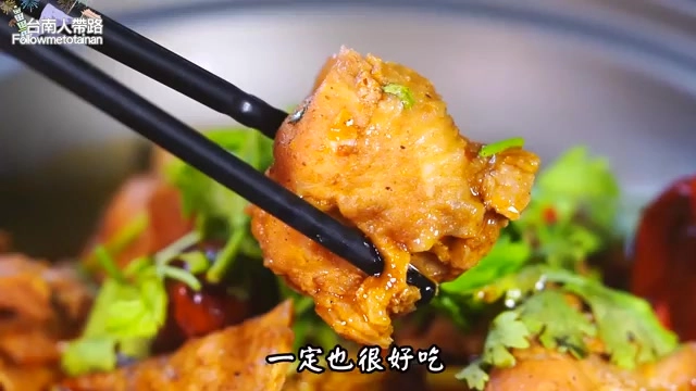 筷子夾起一塊裹滿醬汁的雞肉，搭配翠綠香菜點綴，色澤誘人
