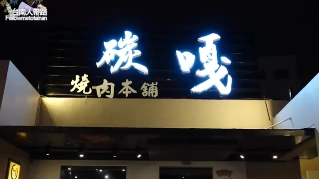 夜間店面招牌，白色霓虹燈字寫著「碳嘎」與「燒肉本舖」