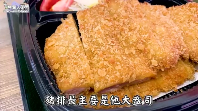 切片的炸豬排排列整齊，外皮金黃酥脆，搭配生菜與燙熟毛豆