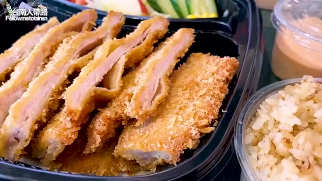 炸豬排切片整齊排列，佐以生菜與紅蔥拌飯，色澤金黃誘人