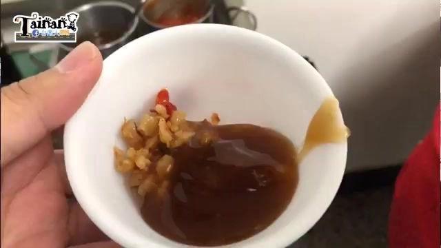 小碗中盛著深褐色醬油膏,混著辣菜脯顆粒與朝天椒