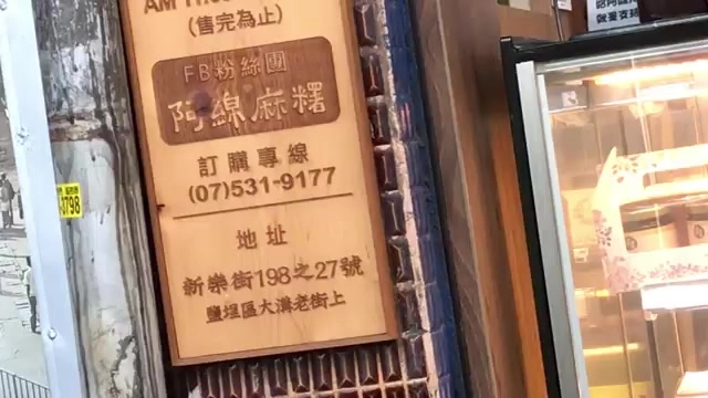店家木牌上寫著「阿綿麻糬」,標示訂購專線與地址「新樂街198之27號 鹽埕區大溝頂老街上」