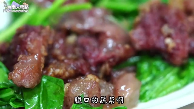 深色醬汁裹著炒牛肉片，鋪在翠綠燙青菜上，色澤油亮