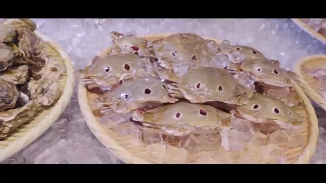 冰塊上擺著多隻新鮮螃蟹與生蠔，色澤自然，呈現海鮮的新鮮度
