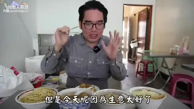 阿波夾起乾麵展示,肉燥鋪滿麵條