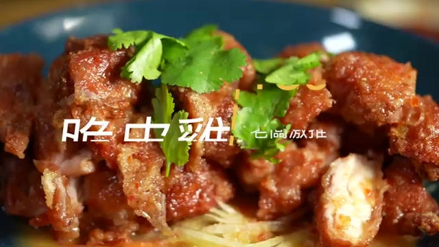盤中盛著泰北脆皮雞,醬汁裹著雞肉塊,撒上香菜點綴