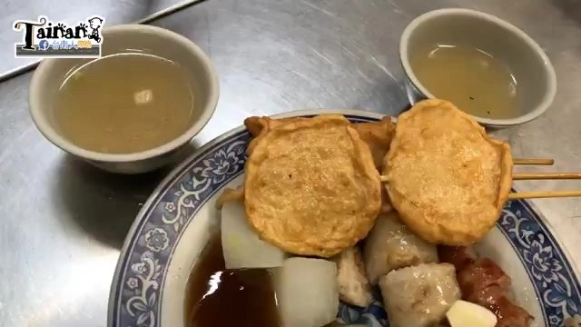 白色瓷盤盛著關東煮食材，包含兩串炸豆皮包蛋、白蘿蔔、貢丸、豬血糕等，旁邊搭配兩碗清湯