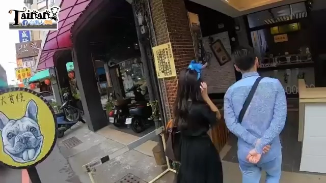 店面外觀，紅色遮陽篷布下停放機車，招牌可見店家標誌