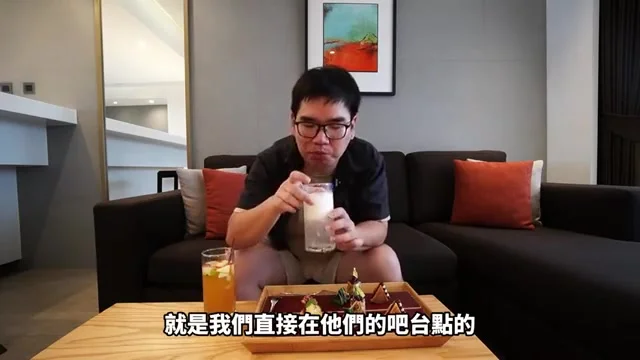 阿波在客廳品嚐吧檯調製的飲品,桌上擺著下午茶點心