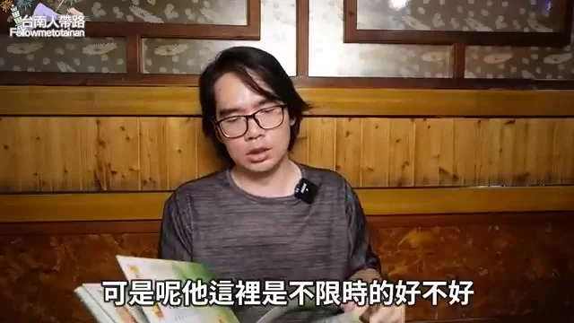 木質調的包廂內部空間,阿波坐在座位上介紹菜單
