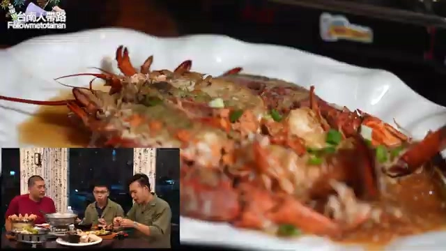 完整龍蝦淋上醬汁擺盤上桌,用叉子夾起一塊龍蝦肉,肉絲清晰可見拉出黏稠光澤