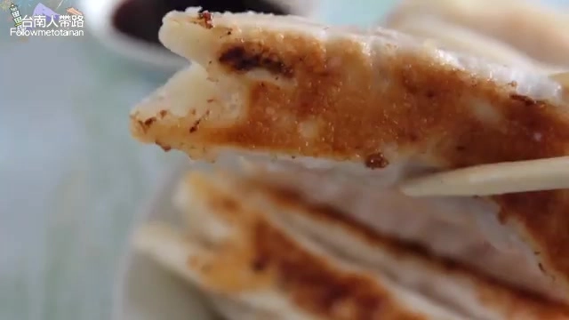 鍋貼外皮煎得金黃焦香,夾起的一顆呈現酥脆的煎面紋理