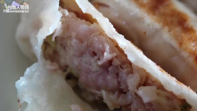 鍋貼剖面特寫,內餡豬肉與高麗菜清晰可見,層次分明