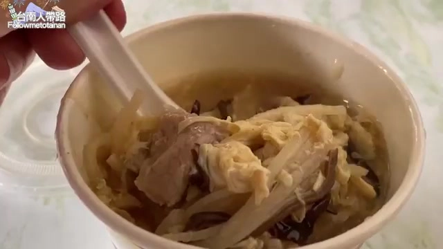 湯碗裡盛著筍絲、肉塊與蛋皮,湯色清澈帶著微微酸香