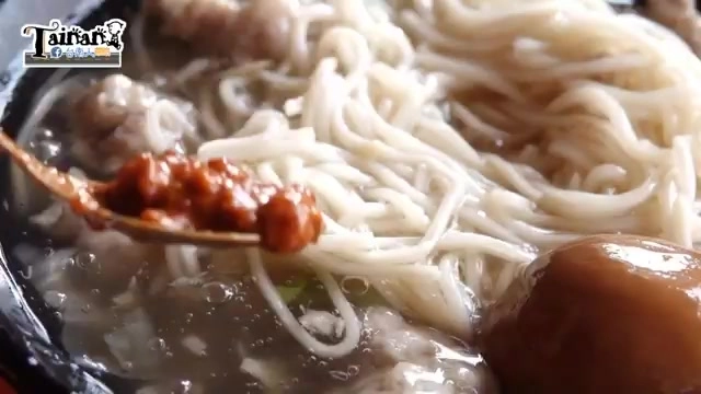 特寫木匙舀起豆瓣醬淋在魯麵上,湯裡還能看到肉羹與滷蛋