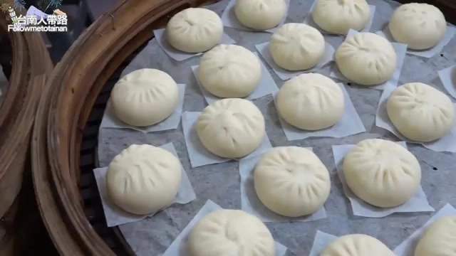 竹製蒸籠裡整齊排列著多顆白胖飽滿的包子，摺紋清晰
