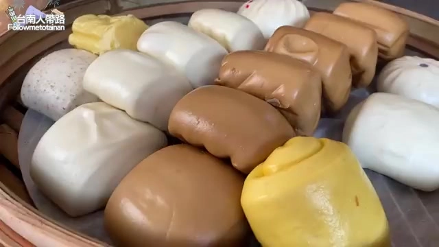 竹籃中盛裝多種口味的饅頭與包子，顏色各異，堆疊整齊