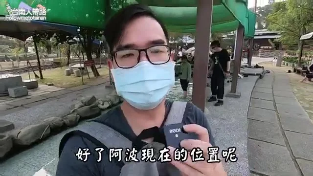 阿波站在龜丹溫泉園區的戶外走道，向鏡頭介紹目前所在位置