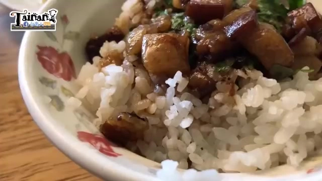 白飯上鋪滿油亮的肉燥塊,撒上香菜提味,色澤深褐誘人