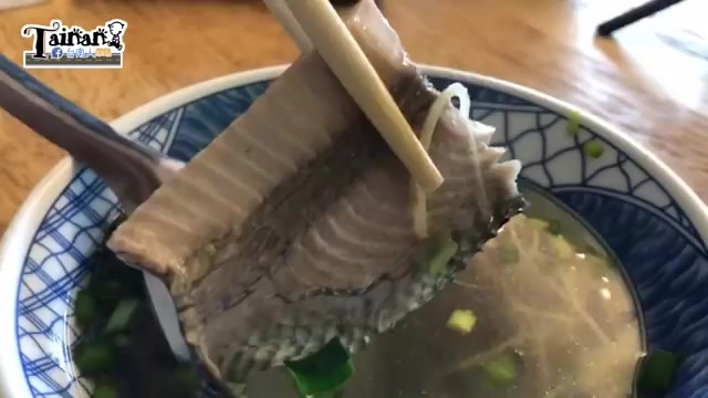 筷子夾起完整的生魚皮,湯色清澈,撒著蔥花
