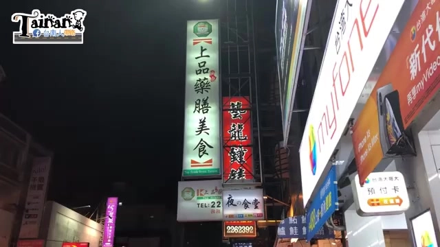 夜晚拍攝的店家招牌，綠底白字寫著「上品藥膳美食」，一旁還有其他招牌與店家標示