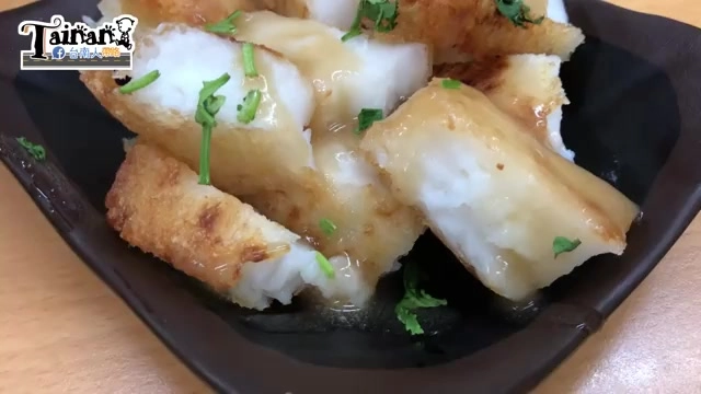 黑色方盤盛著酥炸蘿蔔糕，表面淋著醬汁並撒上香菜點綴，外皮呈現金黃焦香色澤