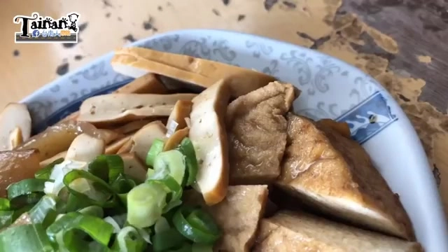 盤中盛著滷味拼盤,可見豆干、豬皮與蔥花,色澤呈現淡褐色