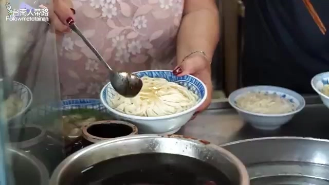 老闆娘從鍋中撈起麵條盛入碗中,準備淋上招牌豬油醬油拌開