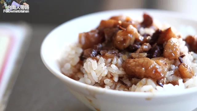 白色瓷碗盛著牛肉燥飯，深色滷汁均勻淋在米飯上，油亮誘人