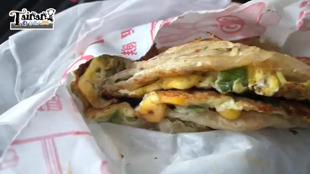 剖開的蔥抓餅夾著蛋、玉米粒與蔬菜，斷面層次分明