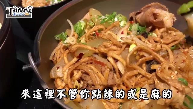 黑色鍋中盛裝辣炒意麵,可見粗麵條與豆芽、蔥花、辣椒交織,色澤紅潤,字幕寫著「來這裡不管你點辣的或是麻的」