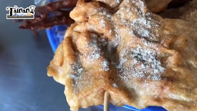 炸得金黃酥脆的甜不辣特寫，表面撒著白色胡椒調味粉