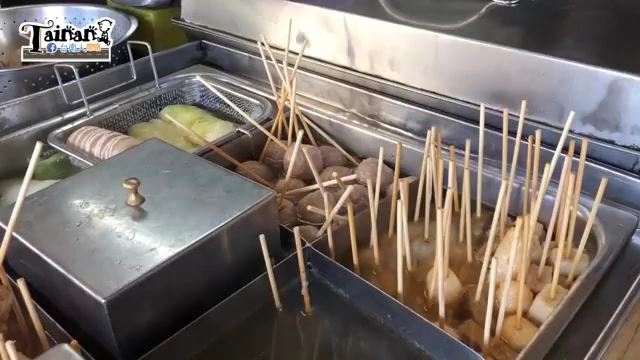不鏽鋼鍋中插滿竹籤的各式煮物食材正在鍋中熬煮，蒸氣裊裊