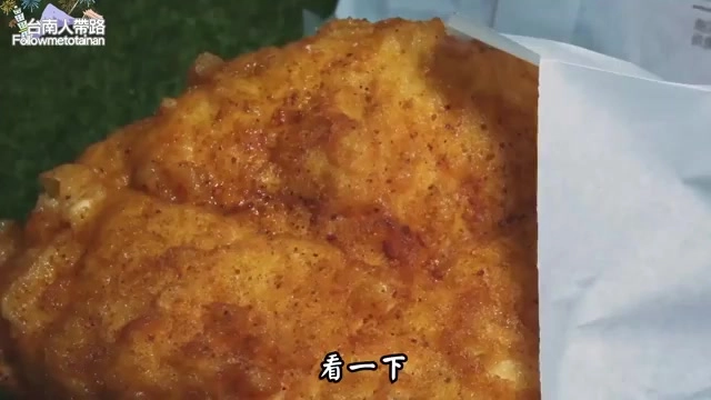 炸雞排表面裹著紅色辣粉，色澤鮮豔油亮，散發辣香