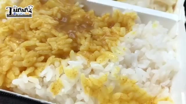 便當盒中白飯淋上兩種醬汁，一側是黃色咖哩醬、一側是白飯原味對照