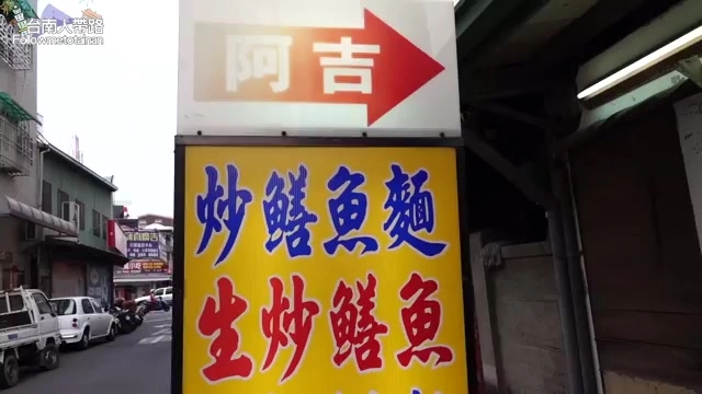 黃底紅字招牌上寫著「阿吉」與指標箭頭,下方標示炒鱔魚麵、生炒鱔魚