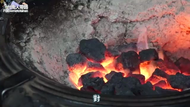 黑色炭爐中熾熱的炭火正旺,橘紅色火焰竄出