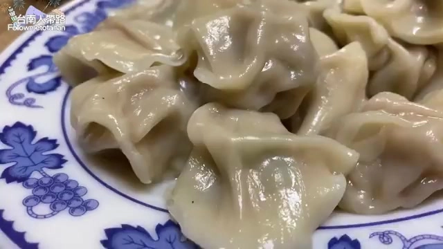 白色瓷盤中盛著多顆剛煮好的水餃，皮薄透亮，摺紋清晰