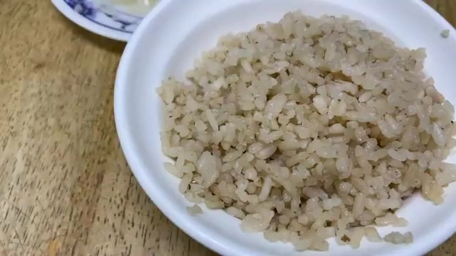 白色瓷碗盛著鬆散的豬頭飯，米粒帶著淡淡油光與香氣