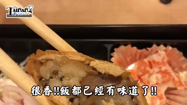 筷子夾起一塊豆皮壽司，可見飯粒與芝麻、牛蒡等配料，字幕寫著「很香!!飯都已經有味道了!!」