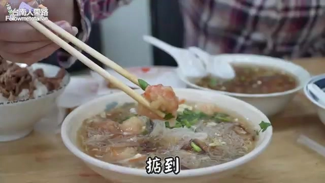筷子夾起花枝羹裡的蝦子,湯色清澈帶著蔥花與香菜點綴