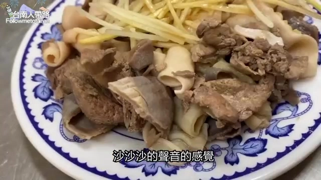 藍白花紋瓷盤上擺著切盤內臟與豆芽菜，深褐色的肝臟與腸類切片交錯排列