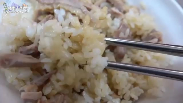 特寫鴨肉飯，鴨肉與米飯緊密混合，色澤呈現淡褐色