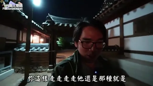 阿波走在金海韓屋體驗館鋪著細沙的庭院步道間，展示傳統韓式建築景致